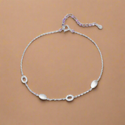 Silver anklet with small round pendants on a white background